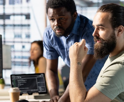 why-businesses-are-outsourcing-website-operations IT professionals monitoring website performance, technical systems, and digital infrastructure in a collaborative workspace.