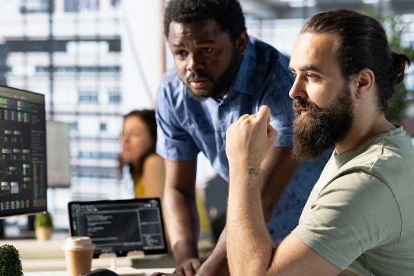 IT professionals monitoring website performance, technical systems, and digital infrastructure in a collaborative workspace.