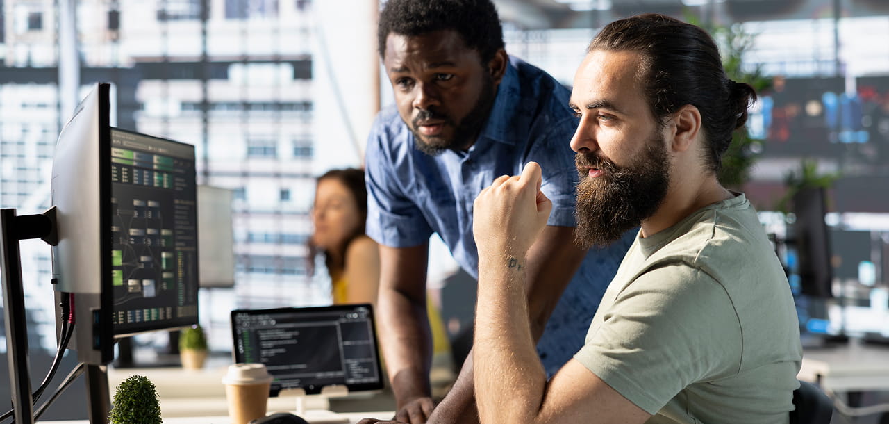 IT professionals monitoring website performance, technical systems, and digital infrastructure in a collaborative workspace.
